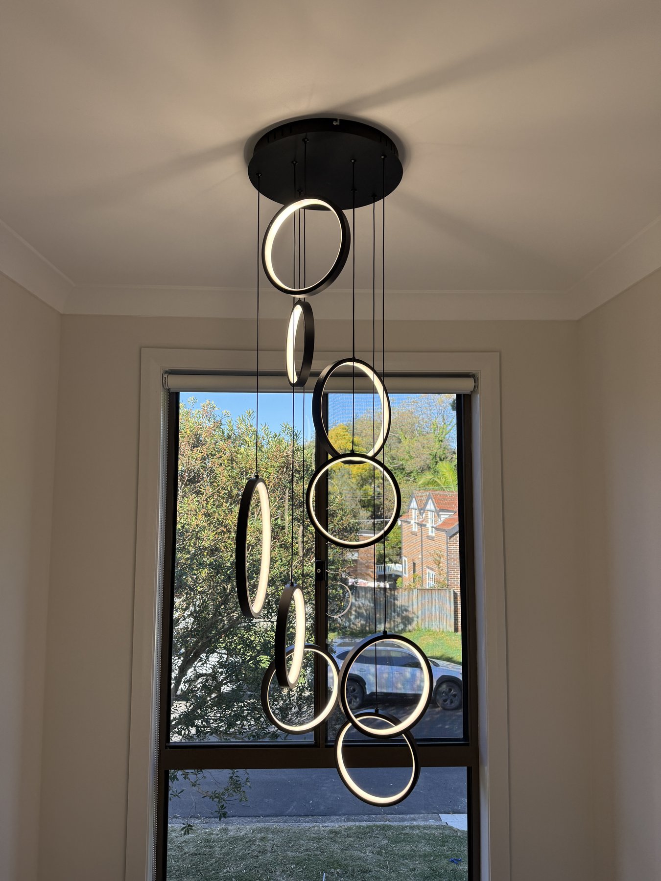 Multi-ring pendant light installation over staircase void